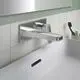 Wandmontierte Waschtischarmatur von Ideal Standard, glänzende Chromoberfläche, mit zwei Griffen und integriertem Wasserabfluss über die Armatur in einem modernen Badezimmer.